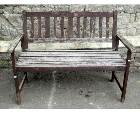 A contemporary but weathered stained teak two seat garden bench with slatted seat and back, 120 cm long (AF) 