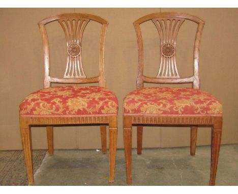 A set of five 19th century dining chairs, the shield shaped backs with pierced comb splats and carved flower head detail over