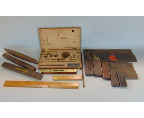 Five vintage wooden handled set squares of graduated size, four small spirit levels, two boxwood rules and a wooden cased bra