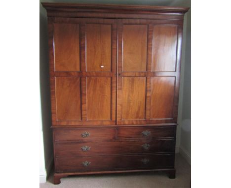 An unusual Georgian mahogany robe/hanging cupboard with moulded and dentil cornice over a pair of rectangular quarter moulded