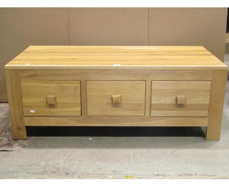 A low contemporary light oak coffee table of rectangular form fitted with six frieze drawers (3 either side with fixed square