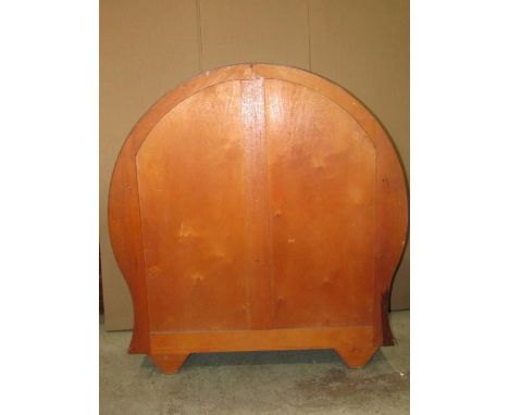 An art deco style walnut veneered display cabinet of circular and slightly waisted form with shaped apron, enclosed by a pair