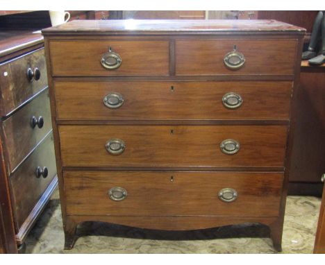 A 19th century mahogany bedroom chest of two short over three long graduated drawers with oval embossed plate handles, shaped