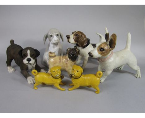 A collection of ceramic models of dogs including a pair of late 19th century yellow glazed models of standing Pugs, 11cm tall