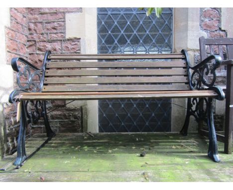 A two seat garden bench with timber lathes and decorative pierced cast iron ends, 130 cm long approx, together with a pair of