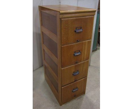 A vintage light oak floorstanding pedestal four drawer filing cabinet with anodised cup handles and moulded panelled sides, 4