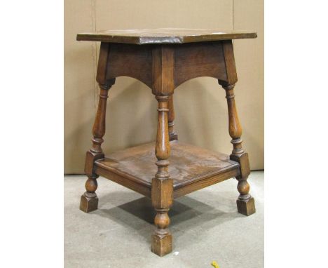 An Arts &amp; Crafts style oak two tier occasional table with copper clad top raised on splayed turned and block supports, 61