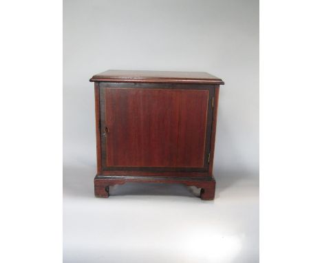 A late 19th century mahogany and fruit wood banded table top cabinet, the hinged lid enclosing a pigeon hole and three drawer