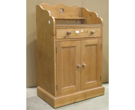 A dwarf floorstanding stripped pine side cupboard/washstand enclosed by a pair of rectangular moulded panelled doors beneath 