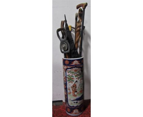 A Chinese Imari porcelain stick stand fitted with various walking canes to include tribal examples, Sunday sticks, shooting s