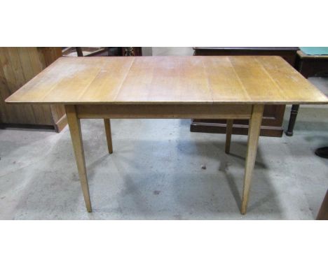 A Russell of Broadway light oak pull out extending dining table of rectangular form with single additional leaf raised on squ