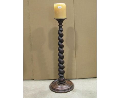 A floorstanding turned oak pricket candlestick with graduated spiral twist column and moulded disc shaped platform base, 83 c
