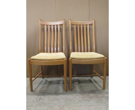 An Ercol light elm pull out extending dining table of rectangular form with moulded outline and single addtional stow away fo