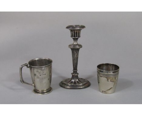 Two silver cups, one with darted band, the other with handle, 6.5 oz approx, together with a further faceted silver candlesti