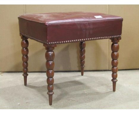 A 19th century rosewood stool of rectangular form with buttoned maroon faux leather upholstered top raised on graduated turne