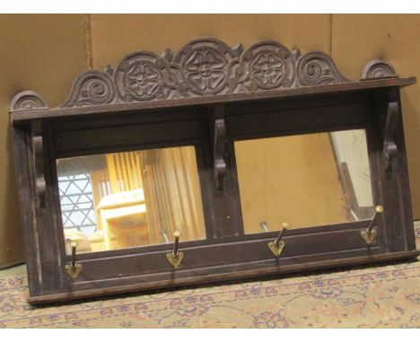 A Victorian oak hall shelf/mirror with carved foliate pediment and moulded frame enclosing two rectangular mirror plates and 