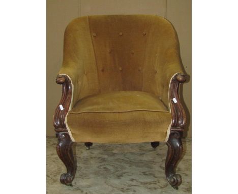 A Victorian spoon back drawing room chair with mustard coloured upholstered seat and button back raised on show wood scrolled