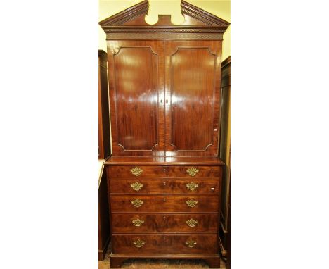 A Georgian mahogany secretaire bookcase, the base fitted with an arrangement of three drawers, disguised as five, the secreta