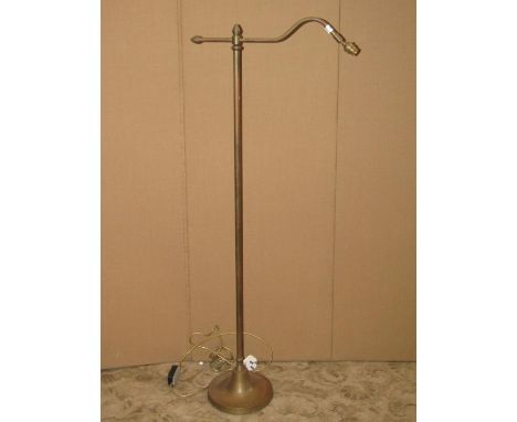 A brass standard/reading lamp with tubular stem and weighted disc shaped platform base 