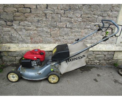 A Honda Izy petrol driven rotary lawn mower 5.5HP engine (starts/runs) probably in need of a service, areas of rust and split