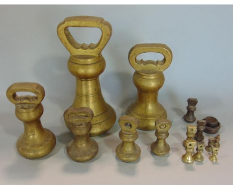 A graduated set of Avery type brass weighing scales, ranging from 7 lb down to 1/4 of an ounce, the largest 18 cm high (a col