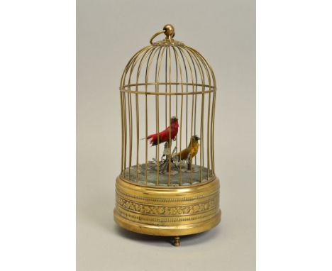 AN EARLY 20TH CENTURY CLOCKWORK AUTOMATON OF TWO BIRDS IN A BRASS CAGE, both birds sing and move beaks, the red bird turns it