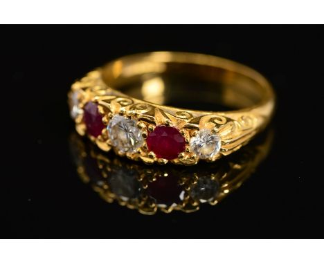 A LATE 20TH CENTURY 18CT RUBY AND DIAMOND CARVED HALF HOOP FIVE STONE RING, scroll carved shoulders and sides, estimated tota