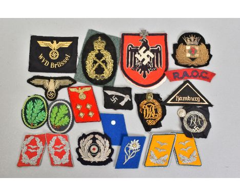A BOX CONTAINING A NUMBER OF BELIEVED GENUINE GERMAN WWI/WWII CLOTH INSIGNIA, including a large red/black/white Eagle Swastik