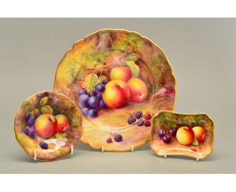 A ROYAL WORCESTER FRUIT STUDY CABINET PLATE, painted with apples, purple grapes and blackberries within a wavy gilt border, s