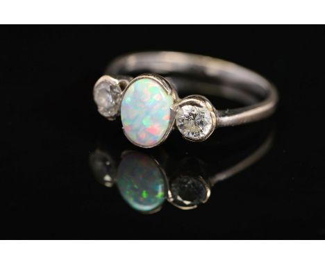 AN 18CT WHITE GOLD, OPAL AND DIAMOND RING, designed as a central oval opal cabochon flanked to either side by a brilliant cut