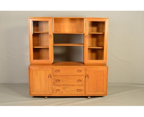 AN ERCOL BLONDE ELM WINDSOR SIDEBOARD/BOOKCASE, model 455D, the top section flanked by two glazed bookcases adjoined by an op