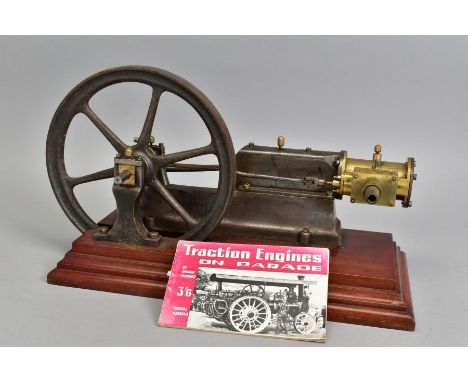 A HORIZONTAL SINGLE CYLINDER LIVE STEAM ENGINE, brass cylinder with inlet pipe, 26cm diameter flywheel, mounted on stepped wo