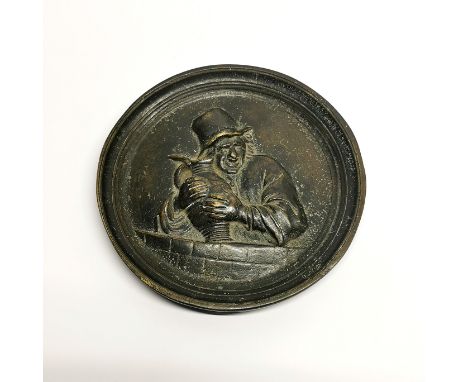 A circular bronze relief plaque of a man and his jug of ale, dia. 15cm.