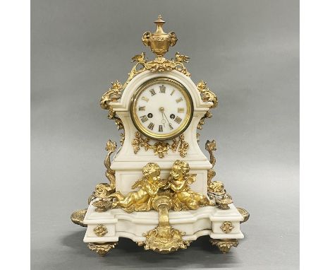 A 19thC French gilt bronze and marble mantel clock decorated with cherubs, H. 35cm.