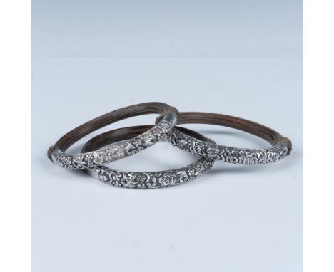 These ornate wooden bangles showcase an intricate floral etching on silver. Measures 3.5"L x 3.25"W. Marked silver. Dimension