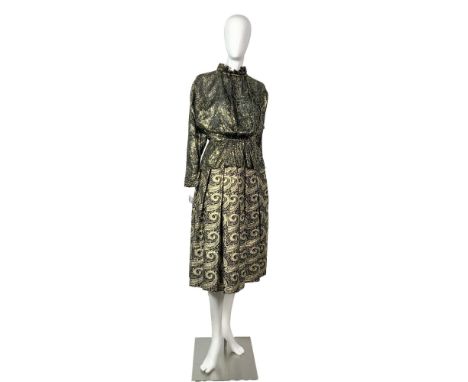 An exquisite vintage two-piece outfit, featuring a black and metallic gold long sleeved blouse with a leaf pattern, accompani