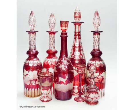   A collection of six Bohemian ruby flashed wheel engraved glass decanters, tallest 40cm, a similar spa beaker and liqueur gl