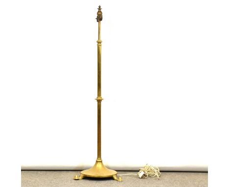 Brass telescopic standard lamp, circular base with three feet, height 136cm.