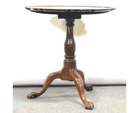 George III mahogany tripod table, probably Irish, the tilt top with pie crust edge, turned baluster column on three legs with