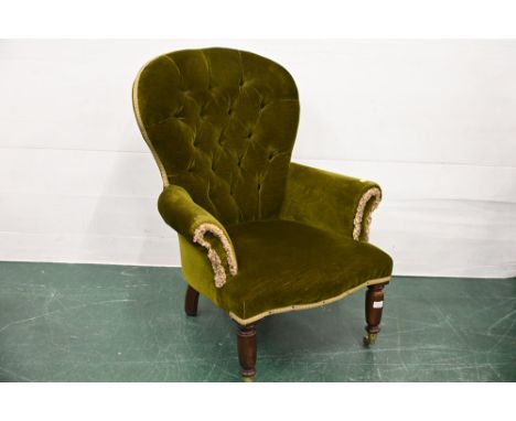 Victorian style deep button back green upholstered chair raised on turned wooden legs with brass castors