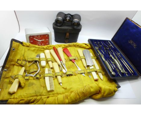 A pair of opera glasses, cased, a travel vanity kit, a cased set of drawing instruments, and a Derby alarm clock 