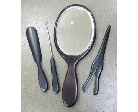 An ebony hand mirror, shoe horn, button hook and glove stretchers 