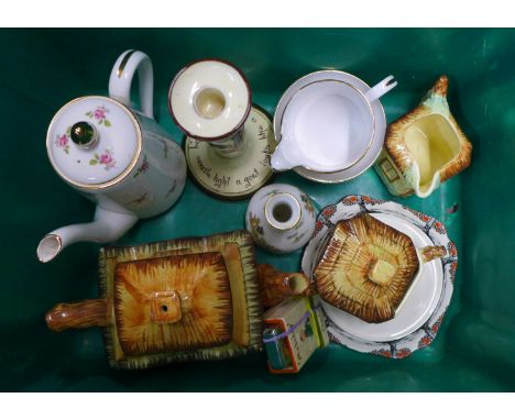 A cottage ware three piece tea service, a three piece coffee service, (small chip to base of coffee pot), a motto ware candle