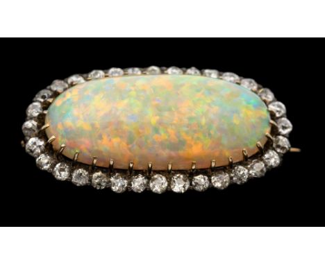An early 20th century opal and diamond set gold brooch, comprising a claw set elongated opal with orange, green, blue play of