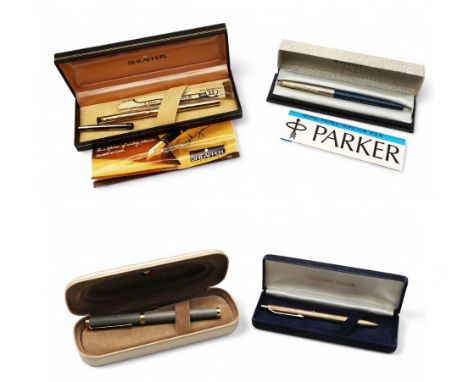 A collection of four pens to include; a 925 engine turned silver pen; a stylish stone style fountain pen with iridium pointed