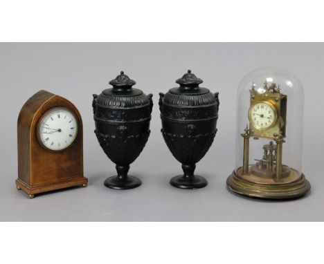 An early 20th century mantel timepiece with black roman numerals to the white enamel dial, &amp; in a walnut case, 8½” high; 