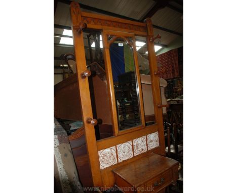 An arts and crafts light Oak Hallstand with carved top rail, six turned pegs, central Gothic moulded mirror, four tiles, cent