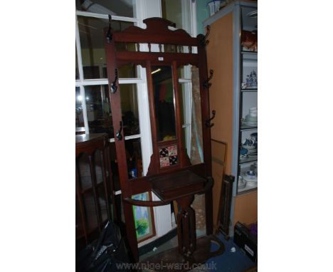 An Edwardian Mahogany Hallstand, having shaped pediment top on spindle turned supports in turn standing on central rectangula