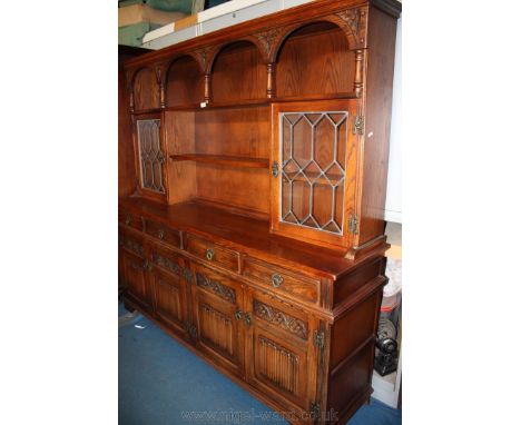 An ''Old Charm'' Lounge Dresser having moulded top over wide top shelf with carved arch and pillar detail, over central short