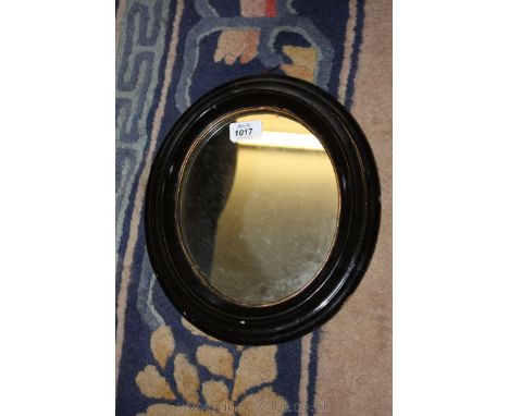 A black painted and gilt oval Wall Mirror, 11'' x 12''.